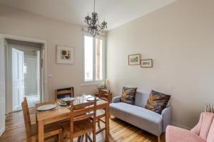 een woonkamer met een eettafel en een bank bij DUCHESSE - Appartement cosy en cœur de ville in Rennes