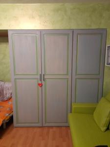 a room with two white cabinets and a green couch at SESTRIERE Fronte Piste in Sestriere