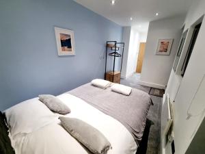 a bedroom with a bed with white sheets and pillows at Superb 2 beds 2 baths New Apartment w/ Garden+Patio in Bournemouth