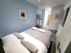 um quarto com uma cama com lençóis brancos e almofadas em Superb 2 beds 2 baths New Apartment w/ Garden+Patio em Bournemouth