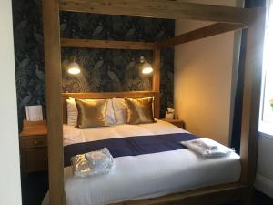 ein Schlafzimmer mit einem Himmelbett und zwei Kissen in der Unterkunft The Continental Hotel, Derby in Derby