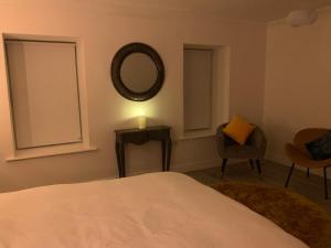 a bedroom with a bed and a mirror and a chair at Alta House in Westport