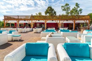 zona de estar con mesas y sillas azules y blancas en Camping maeva Club Le Lagon d'Argelès en Argelès-sur-Mer