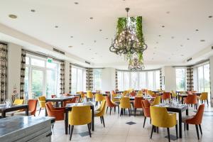 a dining room with tables and chairs and a chandelier at The Spa Hotel in Royal Tunbridge Wells