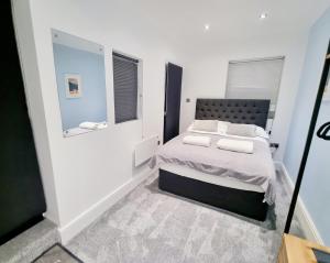 een kleine slaapkamer met een bed en een raam bij Superb 2 beds 2 baths New Apartment w/ Garden+Patio in Bournemouth