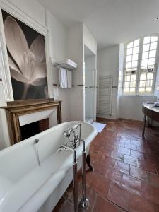 uma casa de banho com uma banheira e um grande quadro na parede em Chambres d'hôtes Relais Mira Peis em Mirepoix