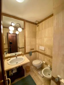 a bathroom with a sink and a toilet and a mirror at Hole 1 - Cozy place on Castelgandolfo Golf Course in Castel Gandolfo