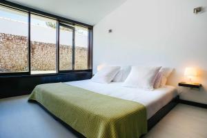 ein Schlafzimmer mit einem großen Bett mit zwei Fenstern in der Unterkunft FOZ DO NEIVA 17 Estadia de luxo em Foz do Neiva E in Moldes + 51 Fotos