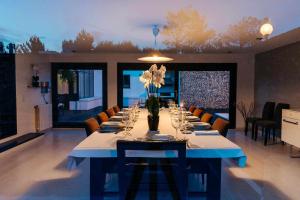 einen langen Tisch mit Gläsern und Blumen in einem Zimmer in der Unterkunft FOZ DO NEIVA 17 Estadia de luxo em Foz do Neiva E in Moldes