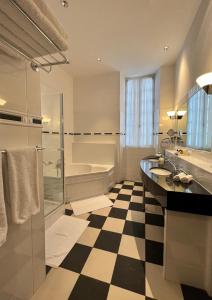 a bathroom with a black and white checkered floor at Chambres d'hôtes Relais Mira Peis in Mirepoix