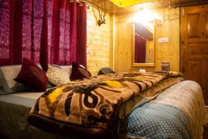 a bed with a blanket on it in a room at Deodar Homestay Dakbangla-kufri in Shimla