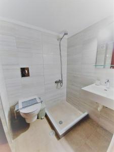 La salle de bains est pourvue d'une douche, de toilettes et d'un lavabo. dans l'établissement Anna's apartments, à Tolón