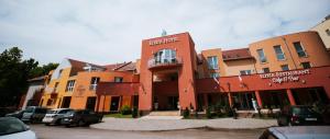 un edificio con coches estacionados frente a él en Elixír Medical Wellness Hotel, en Mórahalom