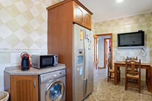 a kitchen with a washer and a refrigerator and a table at La Flor in Chiclana de la Frontera