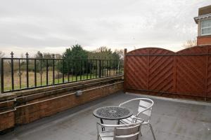 a patio with two chairs and a table and a fence at Skegness The Royal Hotel in Skegness