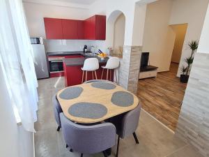 a kitchen with a table and chairs and red cabinets at Apartment Antonio in Banjole