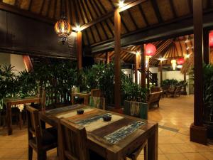 a dining room with a table and some plants at Mojo Resort Canggu in Canggu