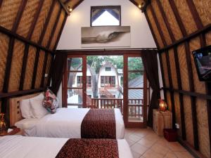 a bedroom with two beds in a room with a window at Mojo Resort Canggu in Canggu +34 photos