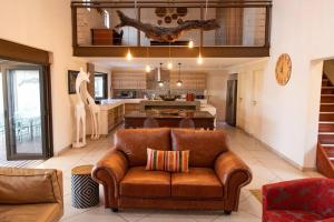 a living room with a couch and a kitchen at Wildheart Safari - MAIN in Hoedspruit