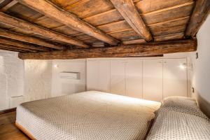 a bedroom with a white bed and wooden ceilings at Casa Vantaggio in Rome