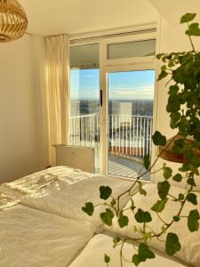 a bedroom with a bed and a large window at Best Butler Skyline Lodge City Apartment Netflix in Augsburg