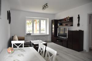 sala de estar con mesa de comedor y TV en Apartament nad fontanną, en Rzeszów