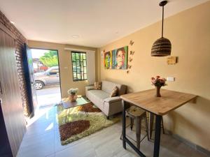 Apartaestudios - Casa Tamarindo في Aracataca: غرفة معيشة مع أريكة وطاولة
