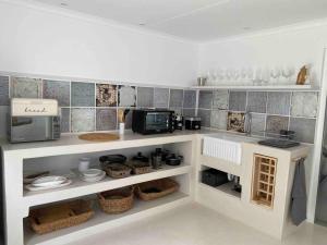 a kitchen with a counter with a microwave and appliances at TAKE TWO lovely beach apartment, Great Brak River in Groot Brak Rivier