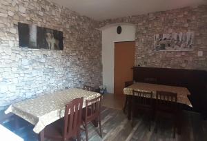 a dining room with two tables and a dog on the wall at Penzion U Dračí skaly in Svojše