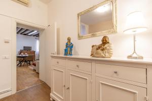 ein Zimmer mit einer Kommode mit einem Spiegel und Statuen darauf in der Unterkunft Ca Maurice - San Marco Canal view in Venedig