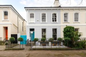 a white house with a fence in front of it at Stunning 2 Bed in the Heart of Cheltenham! in Cheltenham