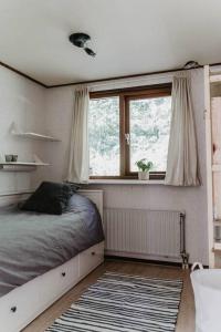 een slaapkamer met een bed, een raam en een tapijt bij BEACH Holiday Home op de Veluwe in Ermelo