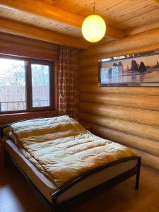 a bedroom with a bed in a wooden wall at У Фёдера и Маргариты in Nizhnyaya Grabovnitsa