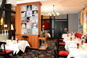 un comedor con mesas blancas y sillas rojas en Boutique Hotel Schieferhof, en Neuhaus am Rennweg