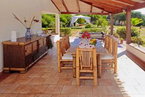 una mesa de madera y sillas en un patio en Alba B&B en Carloforte