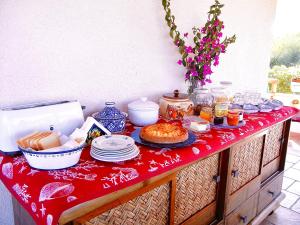 un tavolo con una tovaglia rossa con sopra del cibo di Alba B&B a Carloforte