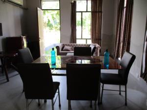 a dining room with a table and chairs at Ganga Kutir Oak Villa on Raichak in Raichak