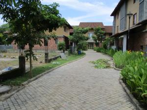 a brick walkway in a yard with a building at Ganga Kutir Oak Villa on Raichak in Raichak