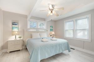 a white bedroom with a bed and a ceiling fan at 118 E ARCTIC UNIT B SALTY SHACK ACROSS THE ST FROM BEACH in Folly Beach