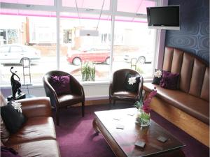 a waiting room with a couch and chairs and a table at The Arthington in Blackpool