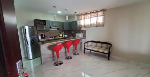 a kitchen with red stools in front of a counter at NCG SUITE Comegua in Guayaquil