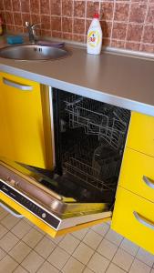uma máquina de lavar louça aberta numa cozinha com um lavatório em Sunrise Apartment em Baošići