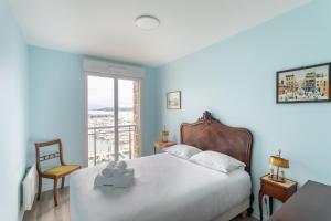 um quarto com uma cama, uma cadeira e uma janela em Ty Granny - Superbe vue sur le port em Saint-Cast-le-Guildo