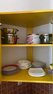 a shelf with plates and pots and pans in a kitchen at Sunrise Apartment in Baošići