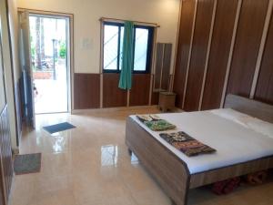 a bedroom with a bed and a large window at Alibaug Sunside Villa 3BHK Near Beach in Alibaug