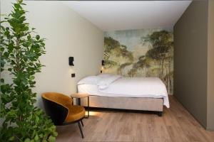 een slaapkamer met een bed en een schilderij aan de muur bij Appart hôtel En Ville in Bastenaken