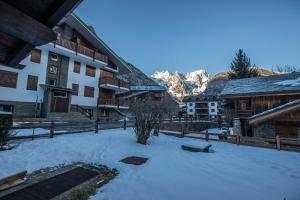 un patio cubierto de nieve frente a un edificio en ALTIDO Family Apt for 6, near Ski Lifts, in Courmayeur, en Courmayeur