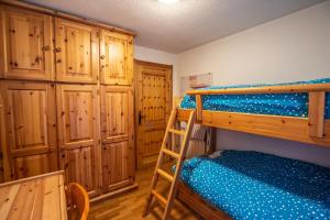 a bedroom with two bunk beds and wooden cabinets at JOIVY Family Apartment, near Ski Lifts, in Courmayeur in Courmayeur