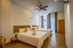 a bedroom with two beds and a ceiling fan at Viva Hotel Phú Yên in Phường Sáu