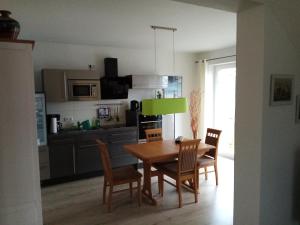 a kitchen with a dining room table and chairs at Haus Fernblick in Breitungen +37 photos